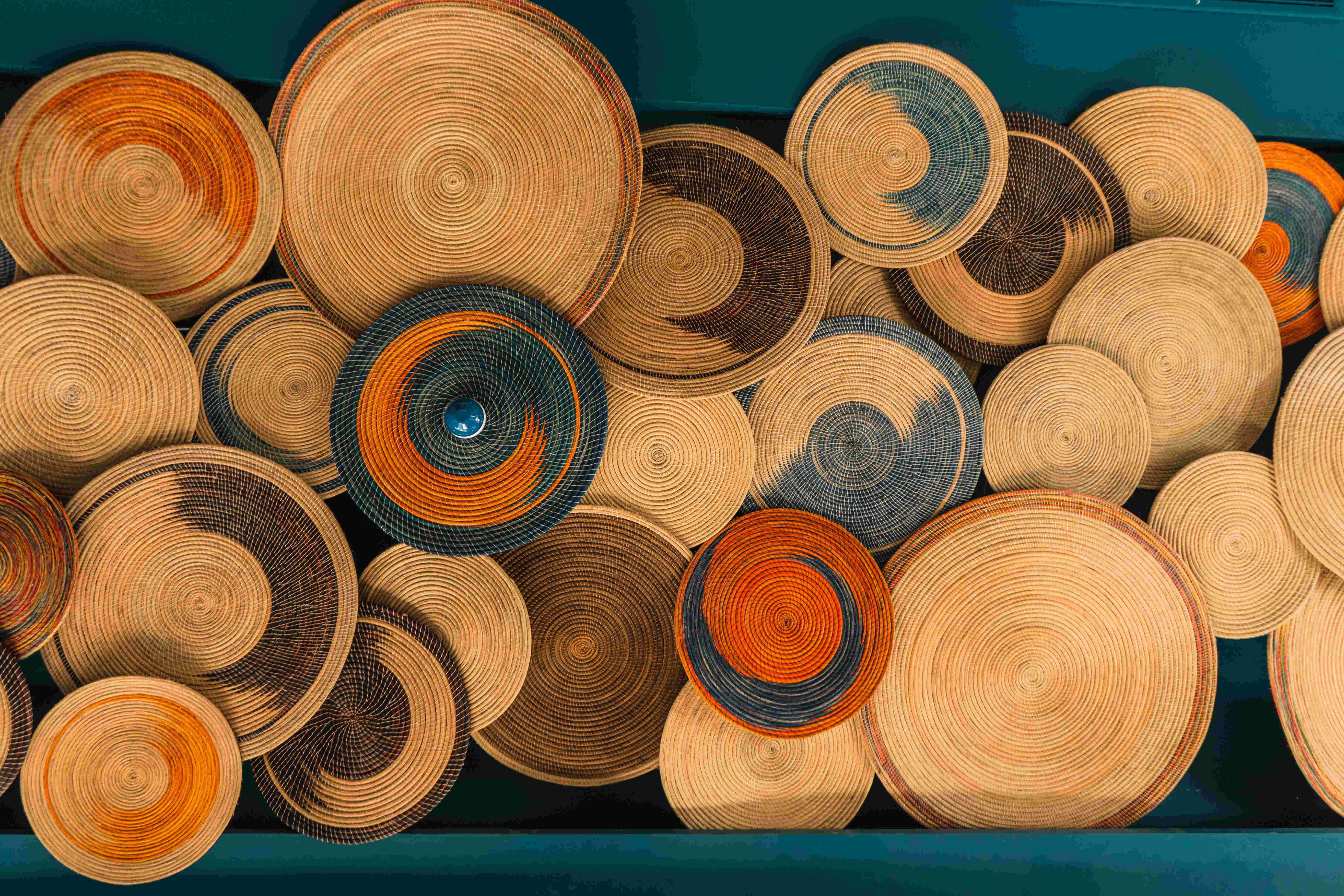 Plateaux en fibres tressées multicolores accrochés au mur