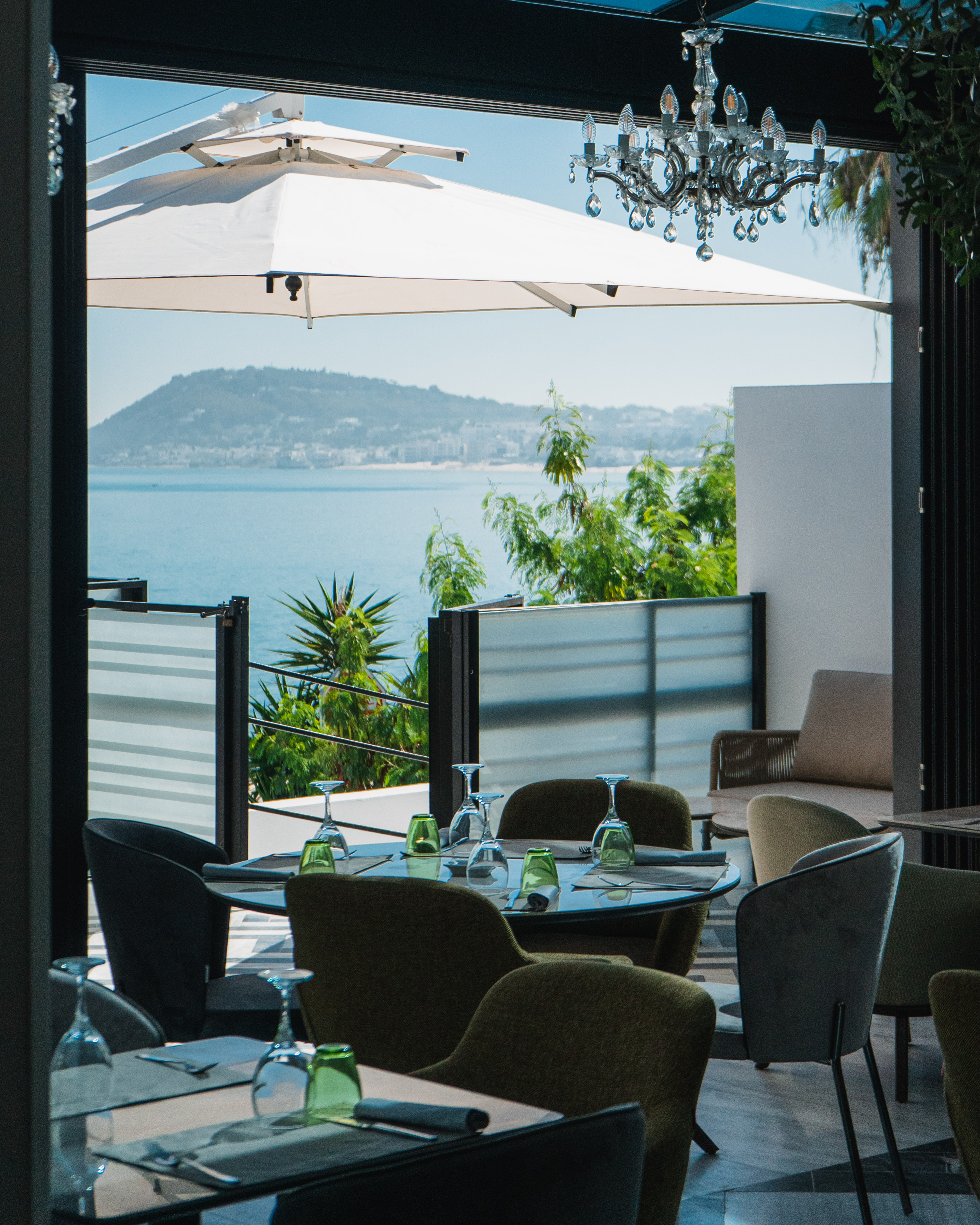 Terrasse de restaurant avec lustre et vue sur la mer