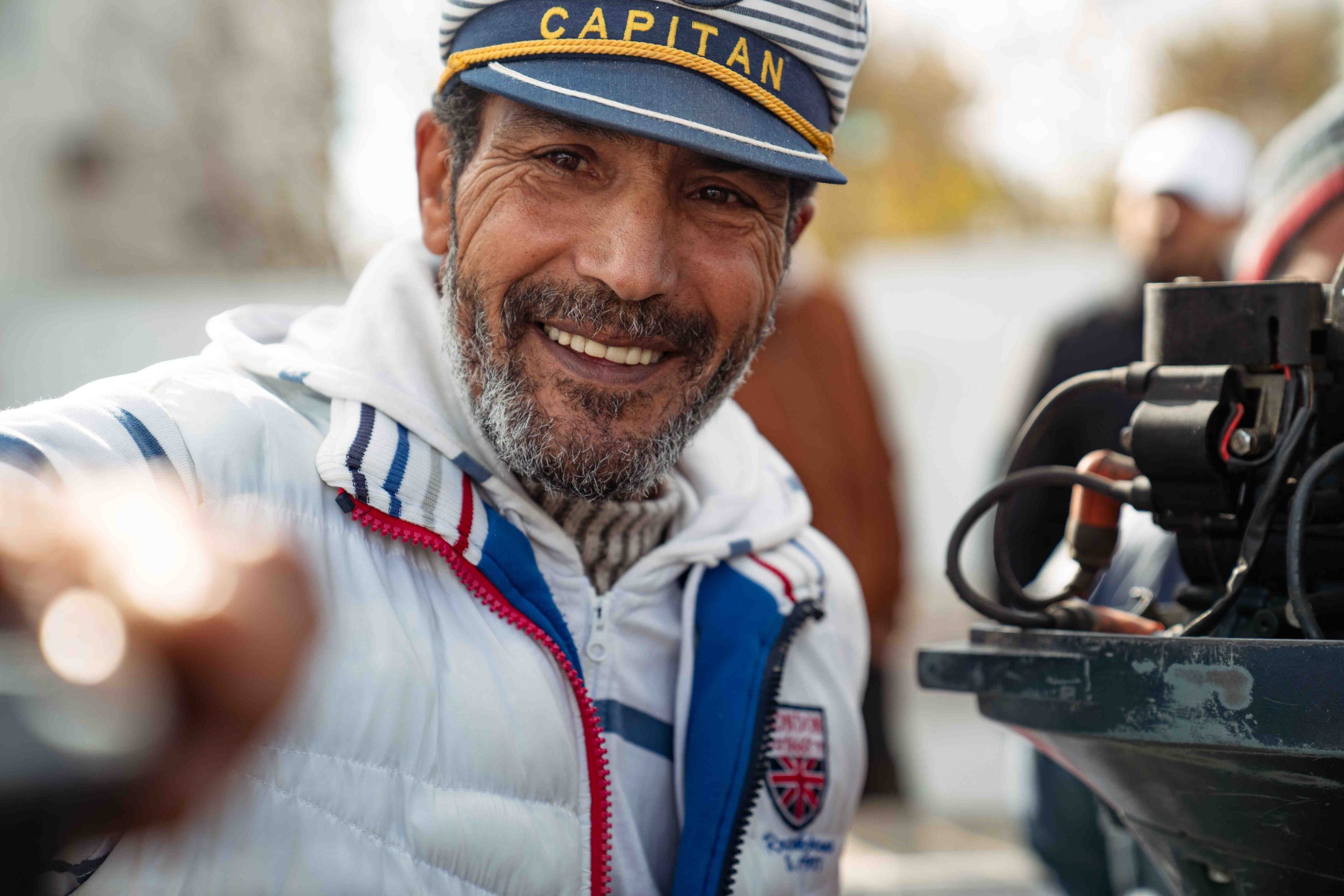 Portrait d'un pêcheur souriant portant une casquette « Capitan »