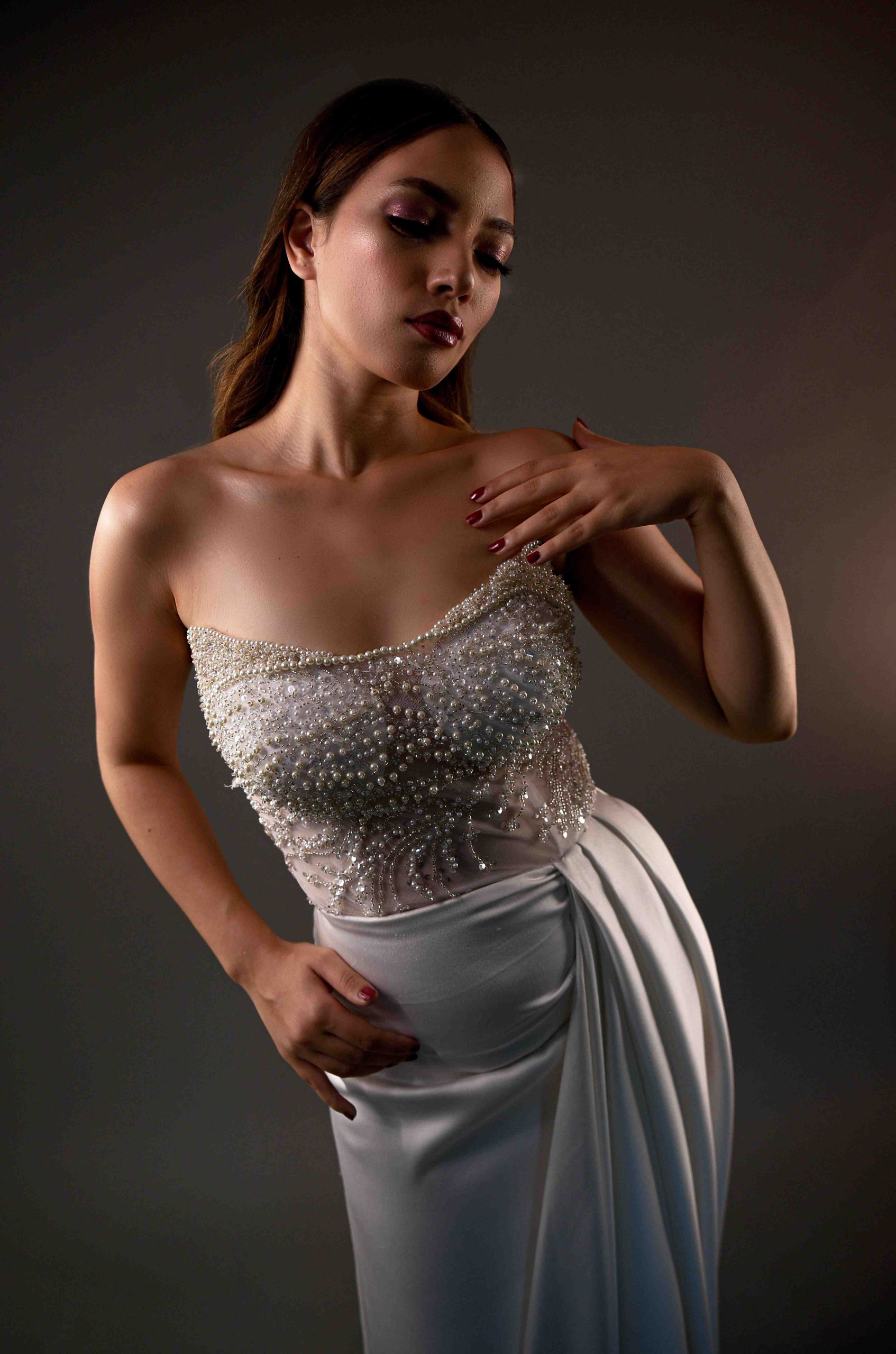 Portrait studio d'une femme en robe bustier brodée de perles
